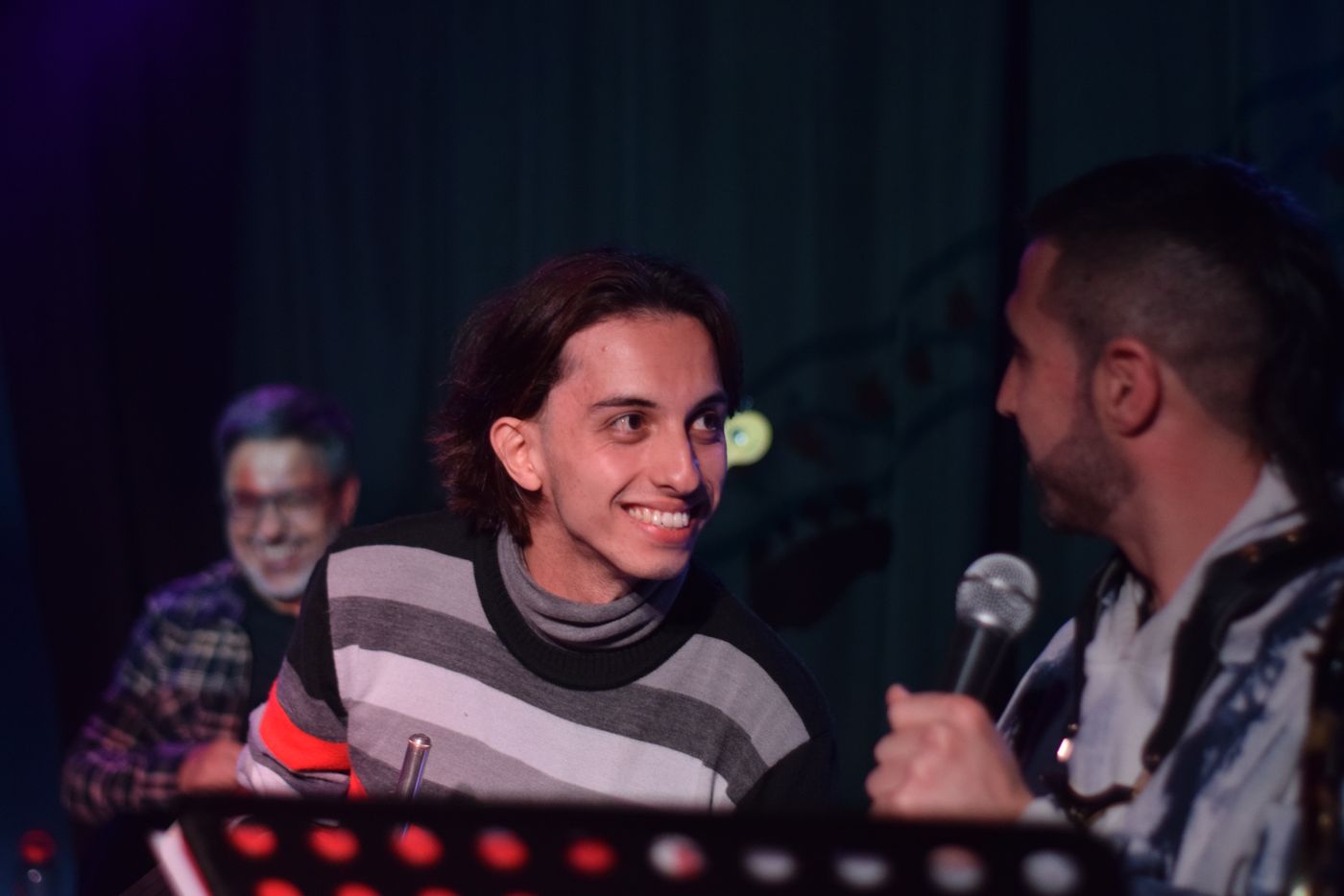 Chico sonriendo entre bambalinas en un show de La Subver
